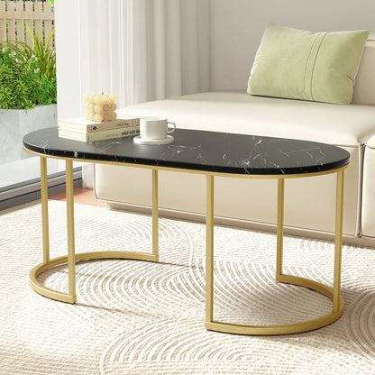 Modern black marble oval coffee table with gold metal legs in a bright living room