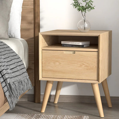Modern light wood nightstand with open shelf, drawer, books, and glass vase in bedroom