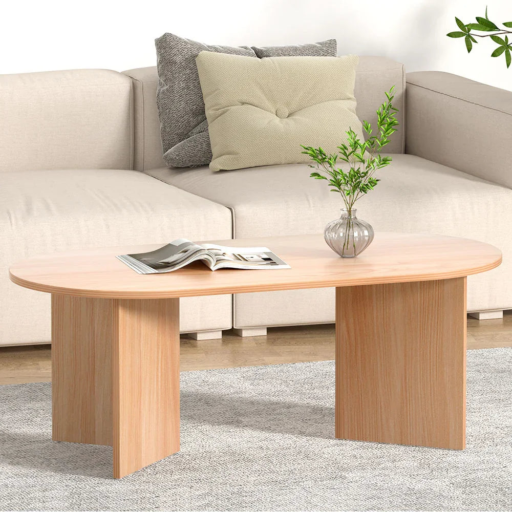 Modern light wood coffee table with vase and magazine in a living room with beige sofa