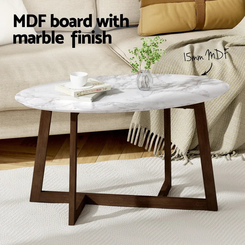 Oval MDF coffee table with marble finish, dark wood legs, in a modern living room setting.