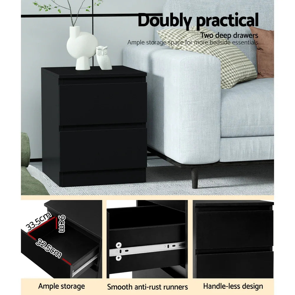Modern black bedside table with two deep drawers, next to grey sofa, minimal decor.