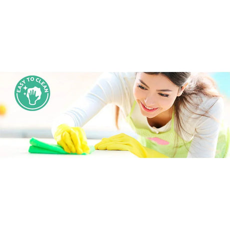 Woman smiling and cleaning surface with yellow gloves, easy to clean symbol visible