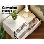 White bedside table with spacious drawers, modern lamp, and potted plant, drawer dimensions shown.