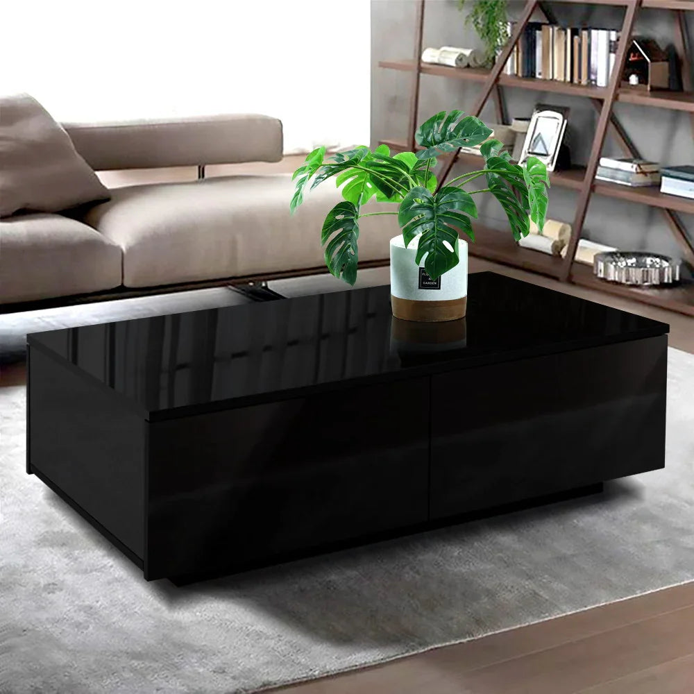 Modern black coffee table with glossy finish and potted plant in contemporary living room