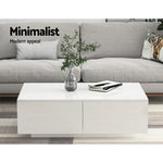 Minimalist white coffee table with books and vase in modern living room with grey sofa