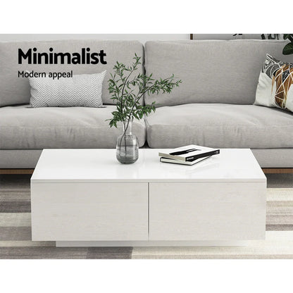 Minimalist white coffee table with books and vase in modern living room with grey sofa
