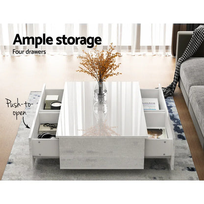 Modern white coffee table with four push-to-open storage drawers and glass vase decor