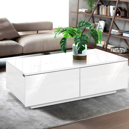 Modern white gloss coffee table with green plant in living room setting