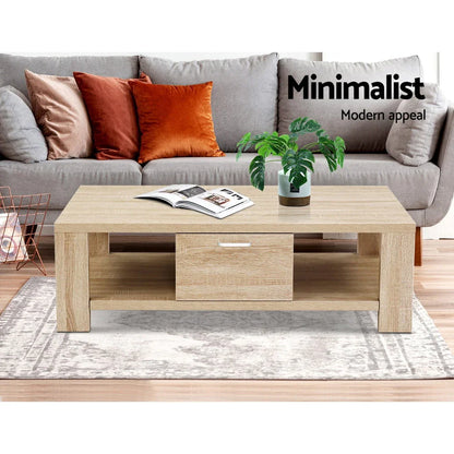 Minimalist wooden coffee table with drawer, potted plant, and magazine in modern living room