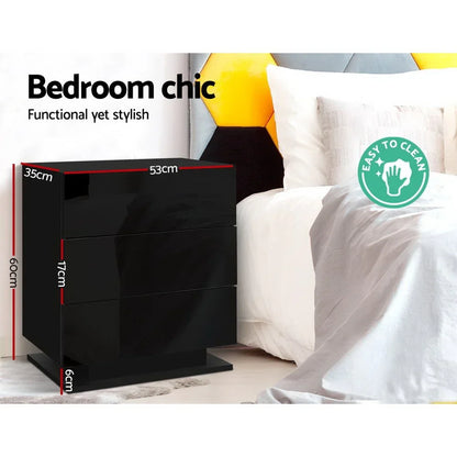 Black glossy bedside table with drawer dimensions next to a white bed, modern bedroom decor