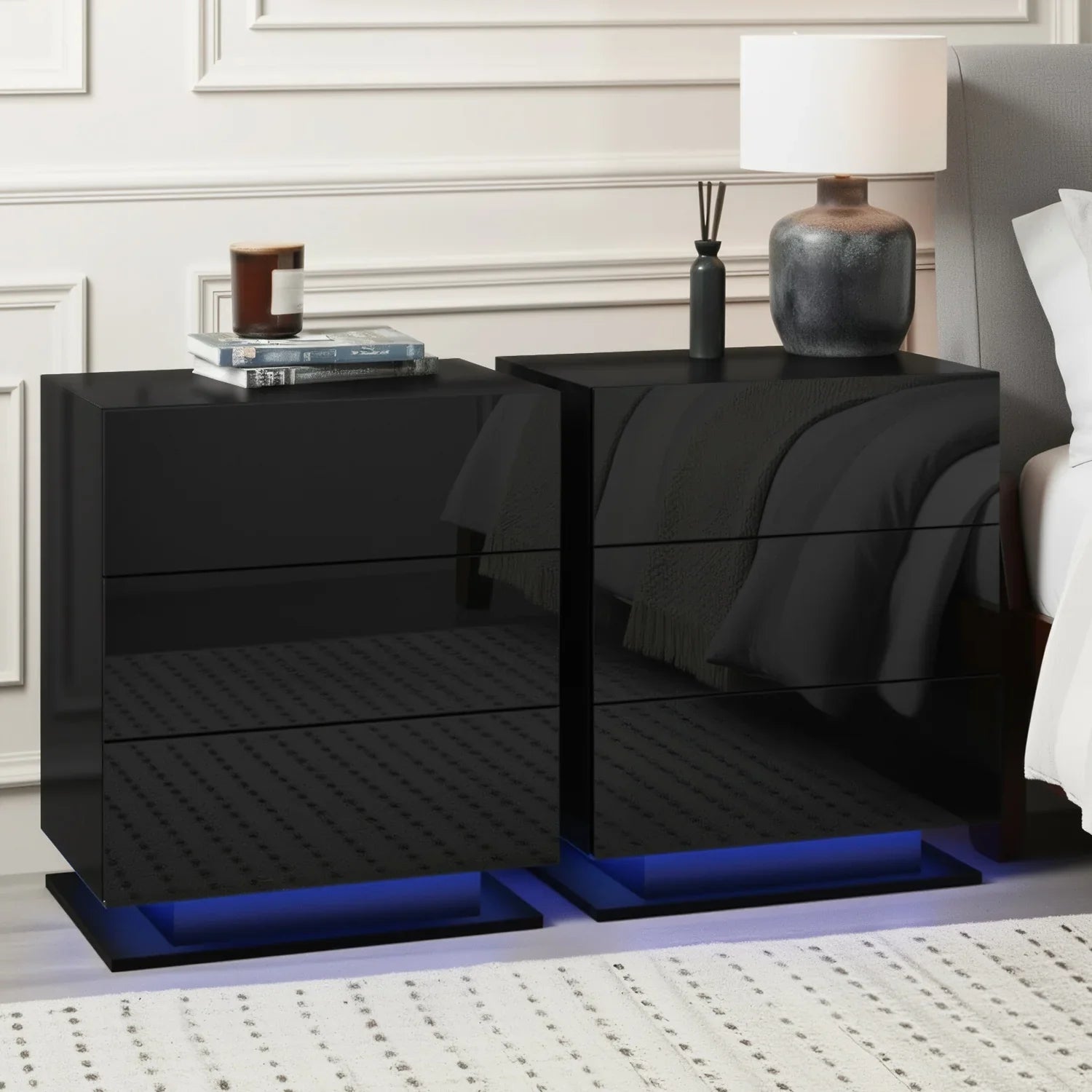 Black high gloss LED nightstands with blue underlighting beside a bed and lamp