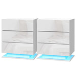 Pair of modern white bedside tables with LED base lighting and glossy finish