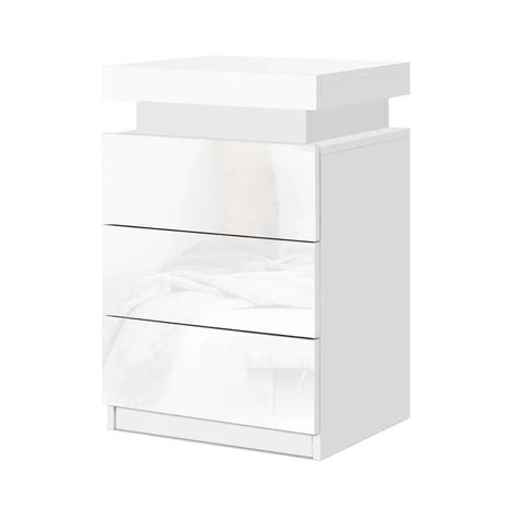 Modern white bedside table with three glossy drawers and minimalist design