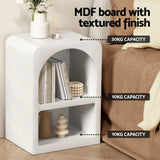 White MDF board bedside table with textured finish, books, and decor items in a modern bedroom.