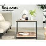Modern wood coffee table with black frame, open shelf, lamp, and plant in living room
