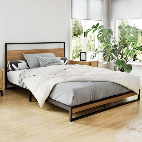 Modern bedroom with wooden and black metal frame bed, neutral bedding, and large green plant by windows