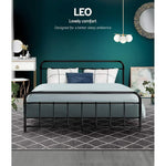 Black metal Leo bed with blue bedding and white pillows in modern bedroom with teal wall and geometric rug