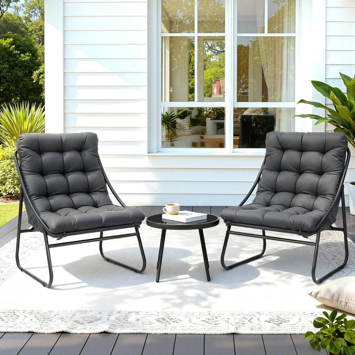 Outdoor patio set with two black cushioned chairs and a round table, modern garden furniture