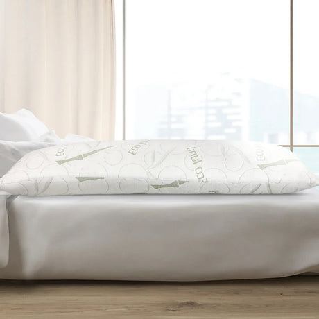 Eco-friendly white body pillow with bamboo design on bed with white sheets near window