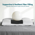 White and black supportive pillow with fiber filling demonstrated by white ball on gray surface