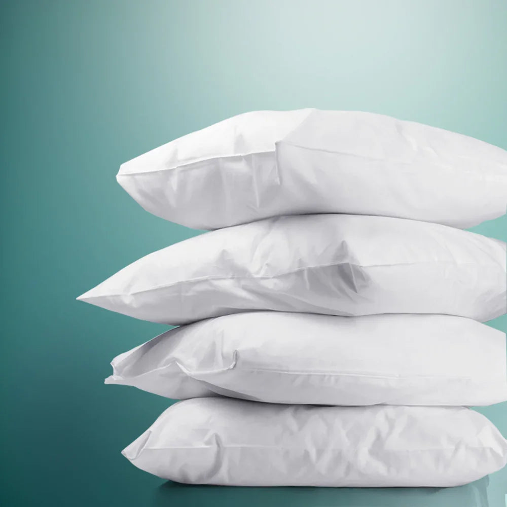 Stack of four white soft pillows against teal gradient background