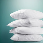 Stack of four white soft pillows against teal gradient background