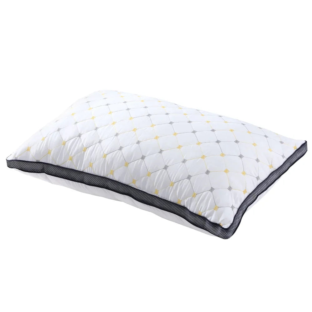 White quilted pillow with yellow and gray diamond pattern and black mesh border