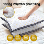 Hand pressing on white polyester fiber-filled pillow with quilted pattern, showing softness and breathability