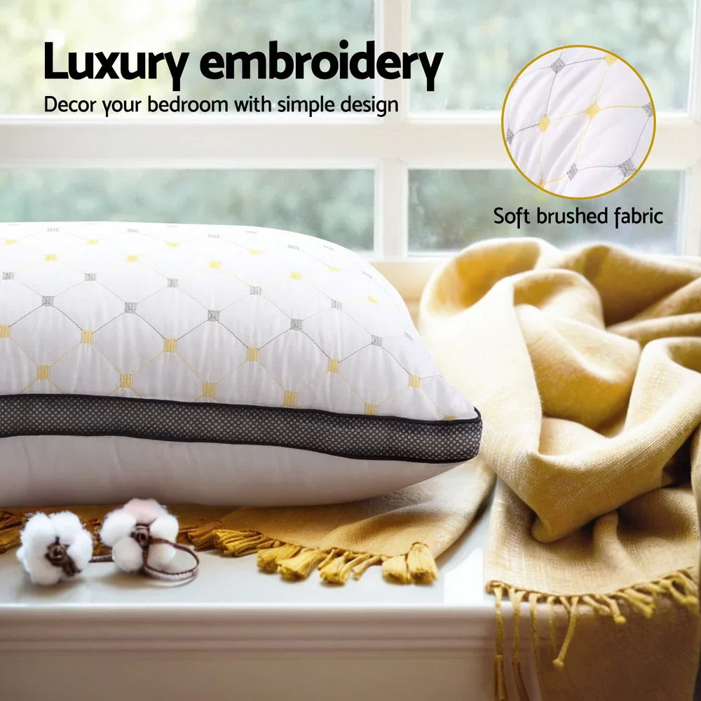 Luxury embroidered white pillow with yellow accents on mustard throw blanket by window