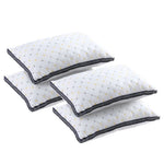Set of four white quilted pillows with yellow and gray geometric pattern and black trim