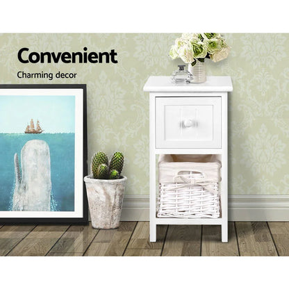 White bedside table with drawer and basket, flowers, and decor in modern room setting