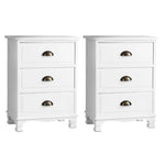 Pair of white three-drawer nightstands with brass cup handles on white background
