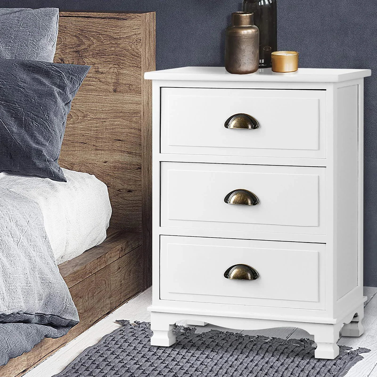White 3-drawer nightstand with gold handles beside a wooden bed, modern bedroom decor