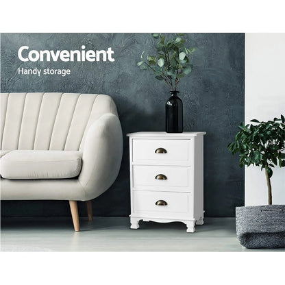 White three-drawer cabinet beside beige sofa, decorative vase on top, modern living room