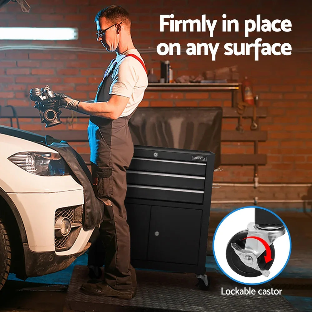 Mechanic working on automotive parts next to a white car with a black lockable caster tool cabinet