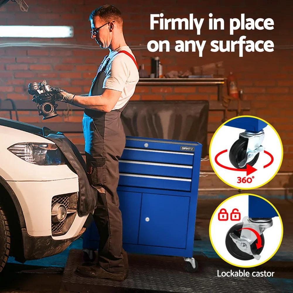 Mechanic in overalls working on car engine next to blue lockable castor tool cabinet in garage