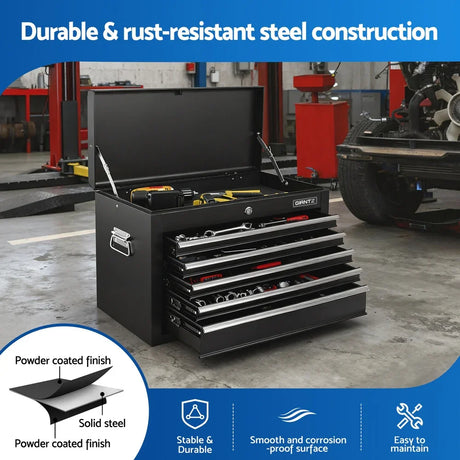 Black steel tool chest with open top and drawers filled with tools in a garage workshop