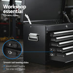 Black workshop tool chest with smooth ball-bearing slides and multiple open drawers on workshop floor