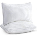 Two white rectangular pillows with textured square pattern and piped edges on white background