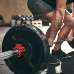 Man in gym shorts deadlifting barbell with 20kg weights on gym floor