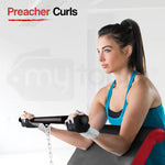 Woman in workout gloves performing preacher curls on exercise bench in gym setting
