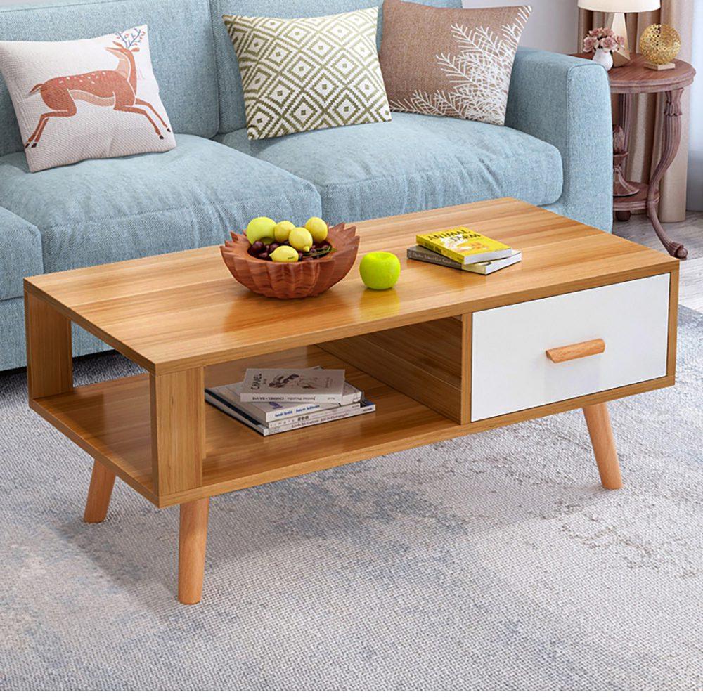 Modern wooden coffee table with white drawer, fruit bowl, and books in living room setting