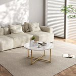 Modern living room with cream sectional sofa, marble coffee table with gold legs, and neutral decor