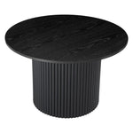 Black round dining table with a ribbed cylindrical base and wood grain texture