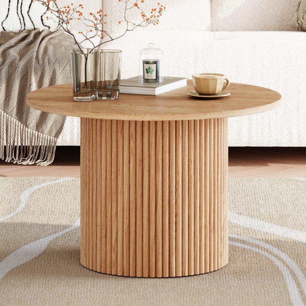 Modern round wood coffee table with ribbed base, cups, candle, and decor in cozy living room