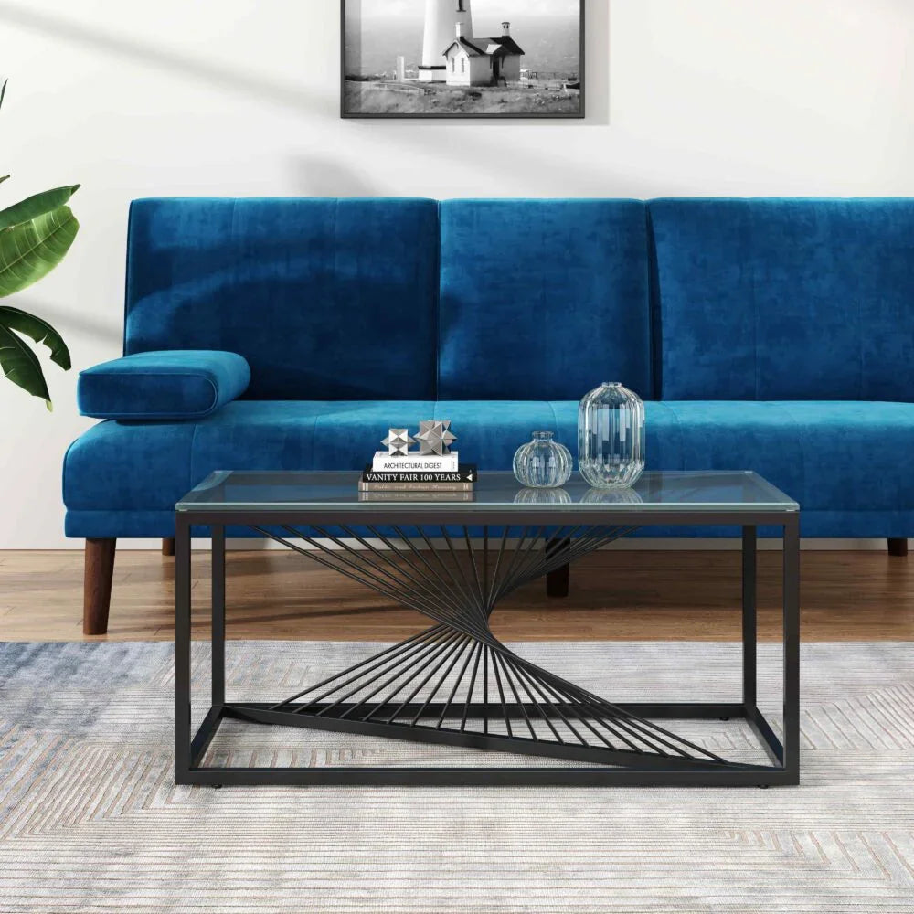 Modern black metal and glass coffee table in front of blue velvet sofa in living room