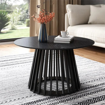 Modern black round coffee table with vase, book, and cup in a stylish living room