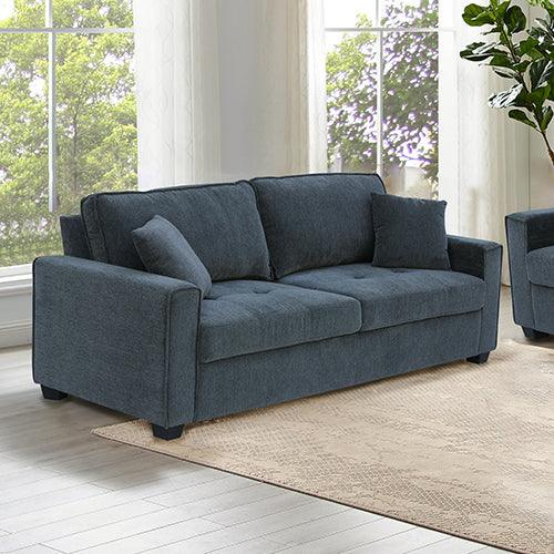 Modern dark gray sofa with two accent pillows in a bright living room with large windows.