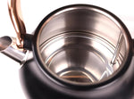 Top view of black electric kettle with stainless steel interior and copper handle
