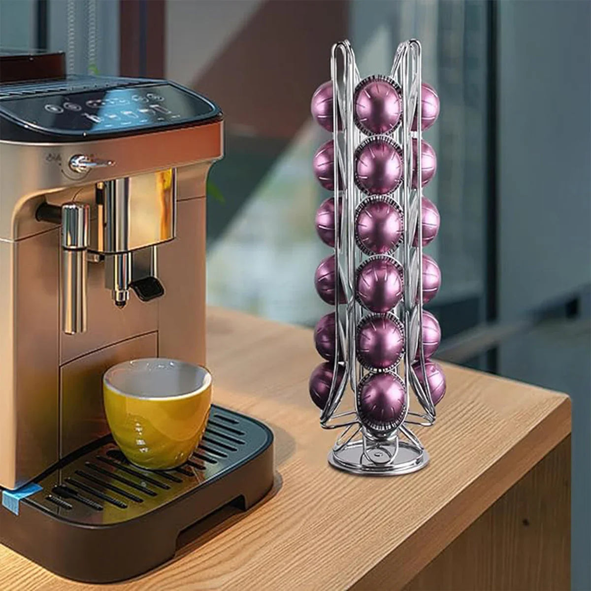 Silver coffee pod holder with purple pods next to yellow cup and espresso machine on wooden counter